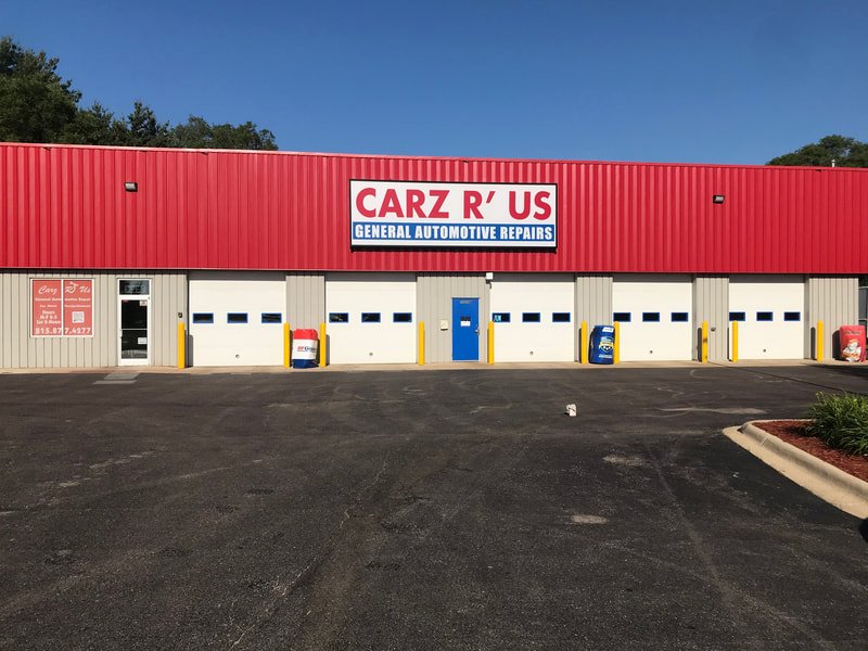 front of the building with four garage doors and the Carz R Us sign on the signature red roof